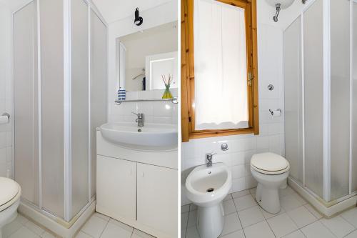 a bathroom with a sink and a toilet and a mirror at Casa relax tra cielo e mare in Bosa