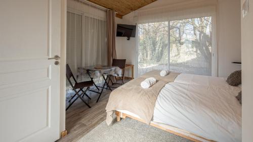 une chambre avec un lit et une grande fenêtre dans l'établissement Les Suites du Jardin 2 - La Chambre du Jour - 2 pers, à Chaumont
