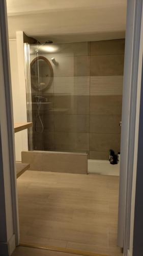 La salle de bains est pourvue d'une baignoire, d'une douche et d'un miroir. dans l'établissement Chez Lucile, à Villeneuve-le-Roi