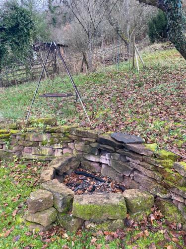 a stone fire pit in a field with a swing at gemütliche rustikale Wohnung mit Kamin und optionalem Whirlpool in Bad Sobernheim
