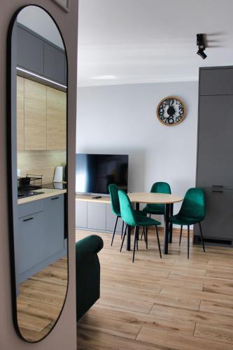 a kitchen and dining room with a table and chairs at Prywatny parking Malachitowy by Rentoom in Toruń