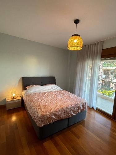 une chambre avec un lit et une grande fenêtre dans l'établissement Sunny Escape - Cottage in Moudania Chalkidiki, à Nea Moudania