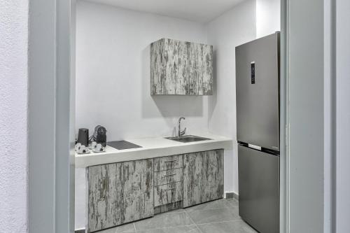 a kitchen with a sink and a refrigerator at Desiterra Resort & Spa in Fira