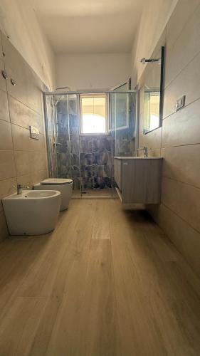 a large bathroom with two sinks and two toilets at Villa thomas torre vado san Gregorio in Marina San Gregorio