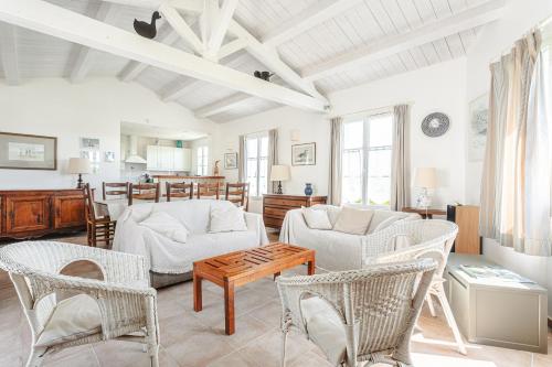 un salon avec des meubles blancs et une table dans l'établissement Maison familiale à 2 pas du port, à Loix