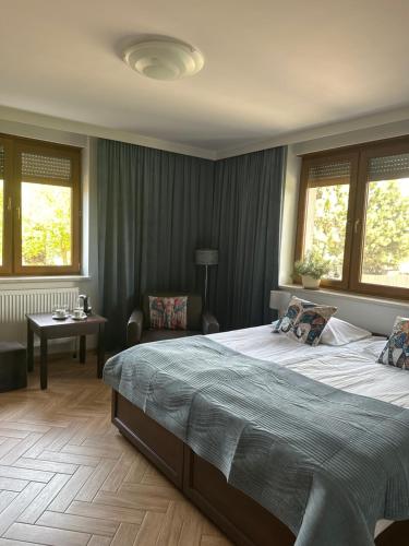 a large bedroom with a large bed and windows at Świat Jezior in Mikołajki