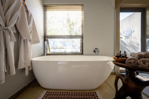 a white bath tub in a bathroom with a window at Rafiki Bush Lodge in Hoedspruit