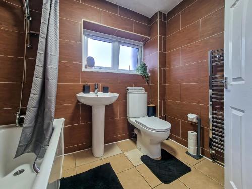 Long LawfordにあるDen Duplexのトイレ、洗面台、窓のあるバスルーム
