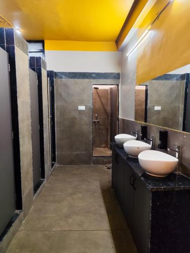a bathroom with three sinks and a yellow ceiling at C2 Pods in Varanasi