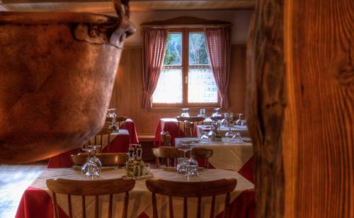 a restaurant with tables and chairs and a window at Affittacamere Alle Trote in Sùtrio