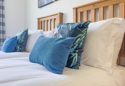 a bed with blue and white pillows on it at Mevagissey Bay Hotel in Mevagissey