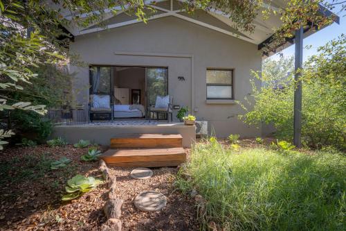 a house with a porch with a bed in the background at Rafiki Bush Lodge in Hoedspruit