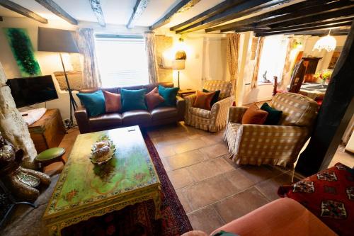 a living room with couches and a table at Christmas Cottage, Isle of Wight in Godshill