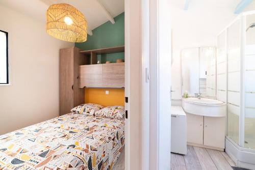 a small bedroom with a bed and a sink at Leucate Aphrodite village in Leucate