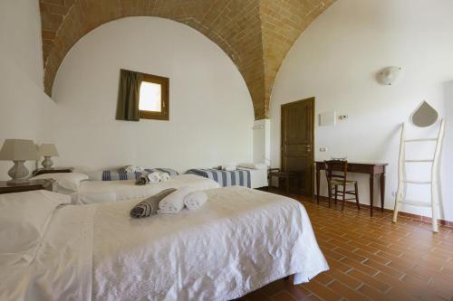 a bedroom with two beds and a desk in a room at Agriturismo La Ca'Solare in Palaia