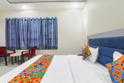 a bedroom with a bed with a colorful blanket on it at Hotel G Inn I in Lucknow