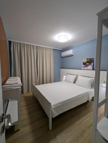 a bedroom with a white bed and blue walls at Solea Suites in Chernomorets