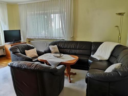 a living room with two leather couches and a table at Ferienwohnung am Schloßpark in Melsungen