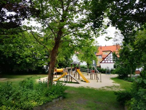 a park with a playground with a yellow slide at Ferienwohnung am Schloßpark in Melsungen