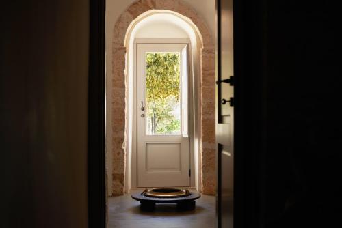 a hallway with a white door and a window at Trulli Mansueto in Noci