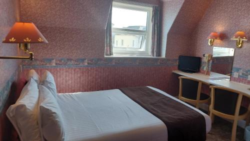 a bedroom with a bed and a desk and a window at White Heather Hotel in Llandudno