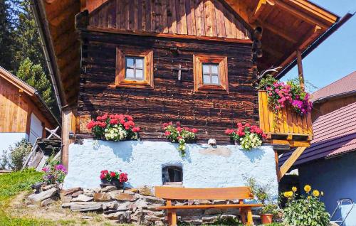 a wooden house with flower boxes and a bench at Ferienhaus Mit Sauna in Stadl an der Mur