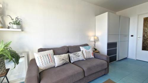 - un salon avec un canapé et des oreillers dans l'établissement Saint Georges de Didonne - PLEINE VUE MER pour ce STUDIO CABINE face à la plage, à Saint-Georges-de-Didonne