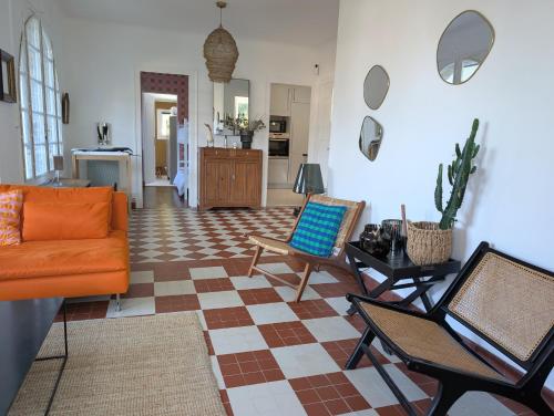 - un salon avec un canapé et des chaises orange dans l'établissement Esprit vacances entre jardin & plage du Porteau, à Pornic