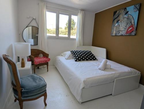 une chambre avec un lit, une chaise et une fenêtre dans l'établissement Esprit vacances entre jardin & plage du Porteau, à Pornic