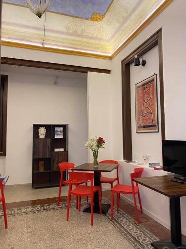 Un comedor con una mesa y sillas rojas. en Soste Normanne, en Palermo
