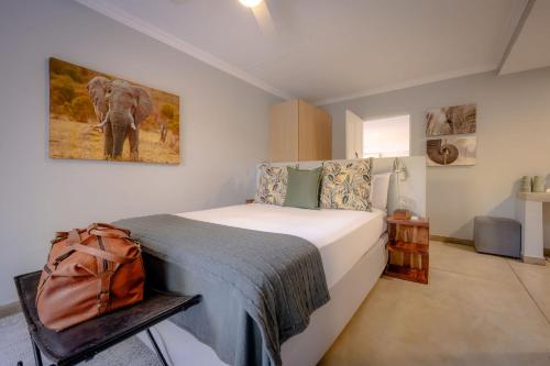 a bedroom with a bed with a backpack on it at Rafiki Bush Lodge in Hoedspruit