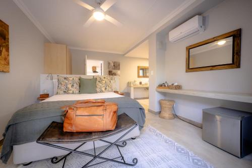 a bedroom with a bed with a brown bag on it at Rafiki Bush Lodge in Hoedspruit