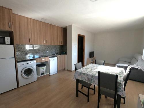 a kitchen and dining room with a table and chairs at Apartamentos de Turismo Rural La Rocha in Fortanete