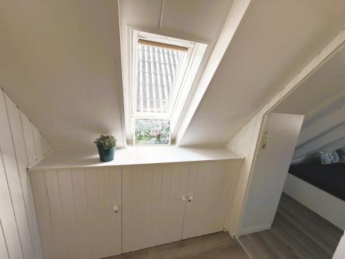 una habitación con una ventana y una planta en un estante en Bulgenshuus Bensersiel, en Esens