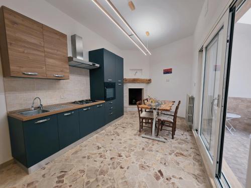 a kitchen with green cabinets and a table with chairs at Astrum - Casa Vacanze a Mesagne in Mesagne