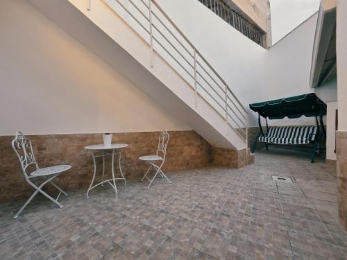 a room with two chairs and a table and a staircase at Astrum - Casa Vacanze a Mesagne in Mesagne