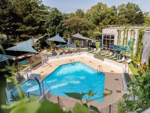 an overhead view of a swimming pool with tables and umbrellas at Novotel Lyon Gerland Musée des Confluences in Lyon