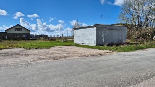 a building on the side of a road next to a house at Korter vanalinna lähistel in Haapsalu