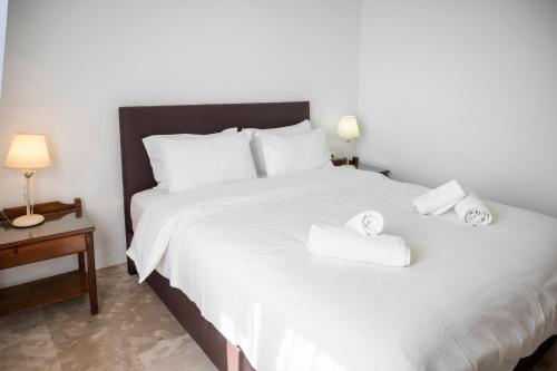 a bedroom with a white bed with towels on it at Argo Rooms-Papadakis in Kissamos