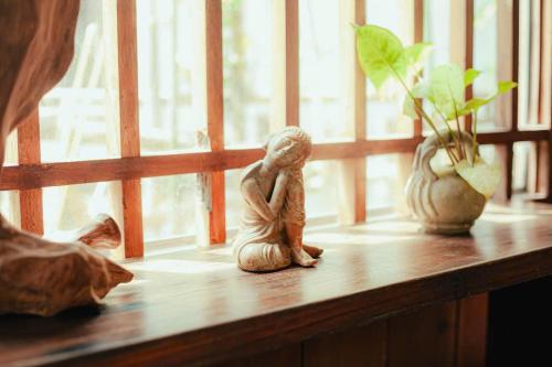 a small figurine sitting on a shelf next to a window at Yên homestay in Hoi An