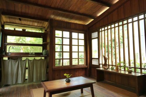 a living room with windows and a table in it at Yên homestay in Hoi An