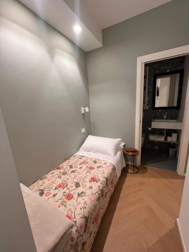 a small bedroom with a bed with a floral blanket at A Casa Di Lu Na 3 in Bologna