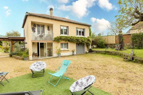 a yard with chairs in front of a house at Maloan, gite avec piscine in Saint-Julien-de-Lampon