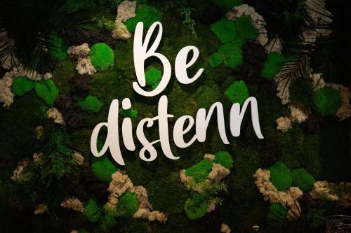 a sign that says be different on top of green plants at Best Western Côte des Sables Plouescat in Plouescat