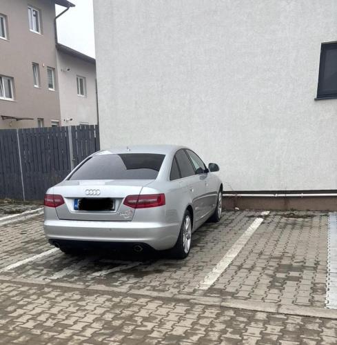 a car parked in a parking lot next to a building at Fok Flat Sibiu in Turnişor