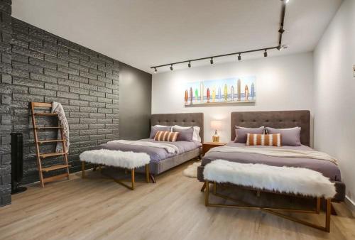 a bedroom with two beds and a brick wall at Socal Style in Encinitas