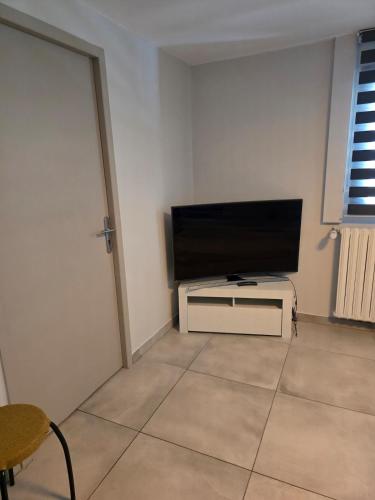 un salon avec une télévision à écran plat sur un mur dans l'établissement Studio in a townhouse, à Annecy