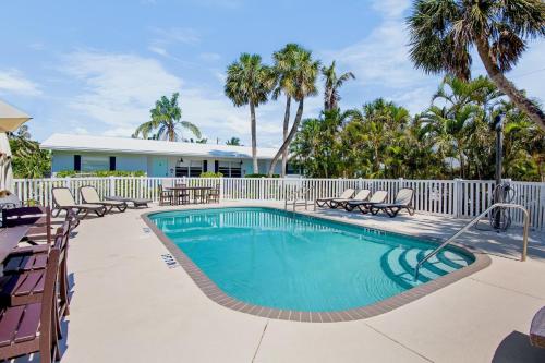 a swimming pool with chairs and a fence at Southern Breeze 2 in Anna Maria