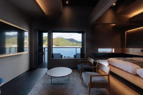 a bedroom with a large window and a bed and a table at Funaya Raku 樂 in Kameshima