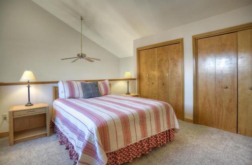 a bedroom with a bed with a striped blanket and a closet at 2 2 Ferringway 26 in Durango